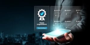 Hand holding a smartphone with holographic certification and checklist visuals above it, symbolizing digital completion.&nbsp;Hispamer Noticias