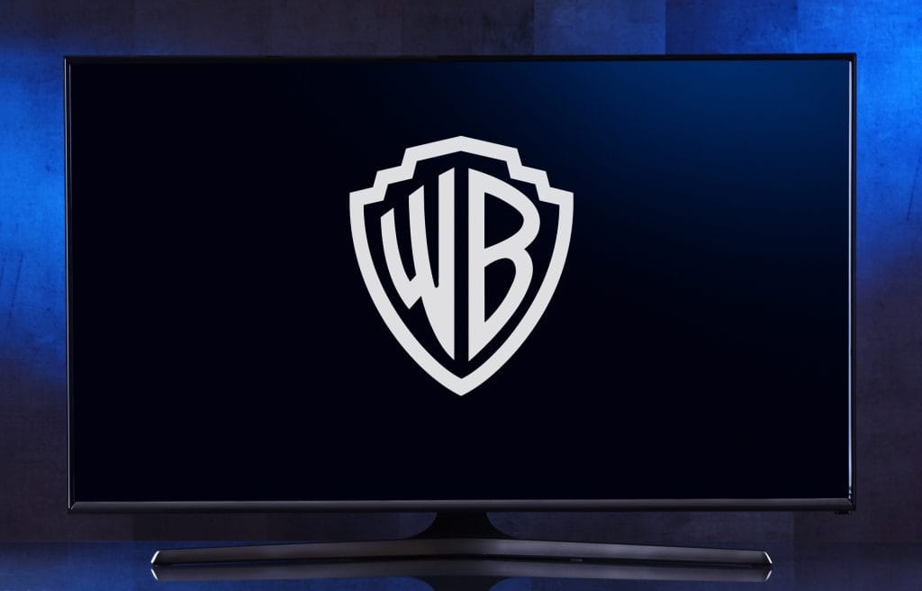 Monitor displaying the white Warner Bros shield logo on a dark screen.