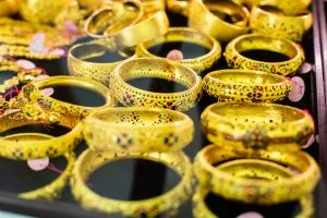 Assorted gold bangles with intricate filigree and colorful enamel on a display tray.&nbsp;Hispamer Noticias