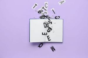 Open book with black letters spilling out onto a purple background, like words escaping from the pages.&nbsp;Hispamer Noticias