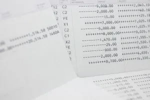 Close-up of financial documents with columned numbers and symbols (ledger/statement pages) scattering across a desk to convey banking data.&nbsp;Hispamer Noticias