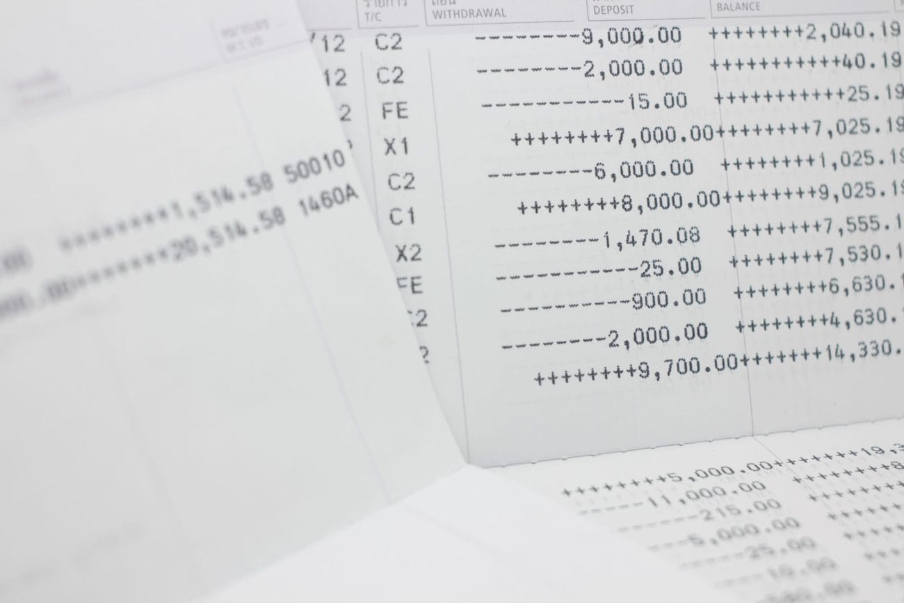 Close-up of financial documents with columned numbers and symbols (ledger/statement pages) scattering across a desk to convey banking data.&nbsp;Hispamer Noticias