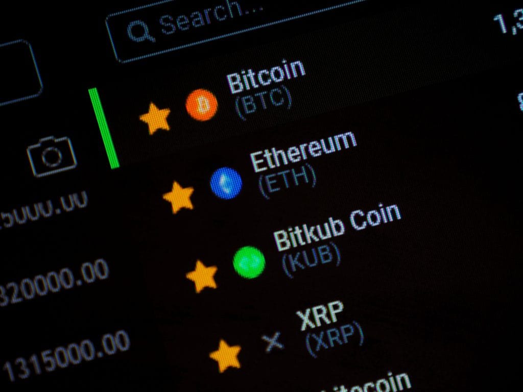 List of favorite cryptocurrencies with colored icons: Bitcoin, Ethereum, Bitkub Coin, and XRP, each with a yellow star indicator on a dark interface.&nbsp;Hispamer Noticias