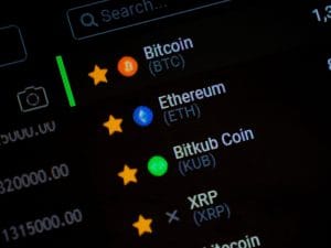 List of favorite cryptocurrencies with colored icons: Bitcoin, Ethereum, Bitkub Coin, and XRP, each with a yellow star indicator on a dark interface.&nbsp;Hispamer Noticias
