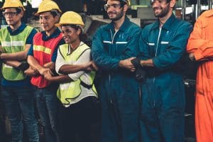 politica laboral - Hispamer Noticias Group of diverse construction workers in hard hats and safety vests smiling with arms crossed in a factory setting Hispamer Noticias