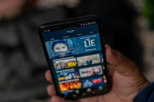 streaming 2 - Hispamer Noticias Person holding a smartphone that displays the Prime Video home screen with movie thumbnails visible on the grid. Hispamer Noticias