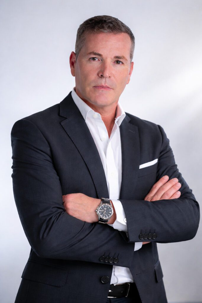 Professional headshot of a man in a dark suit with arms crossed, white shirt, and a wristwatch.&nbsp;Hispamer Noticias