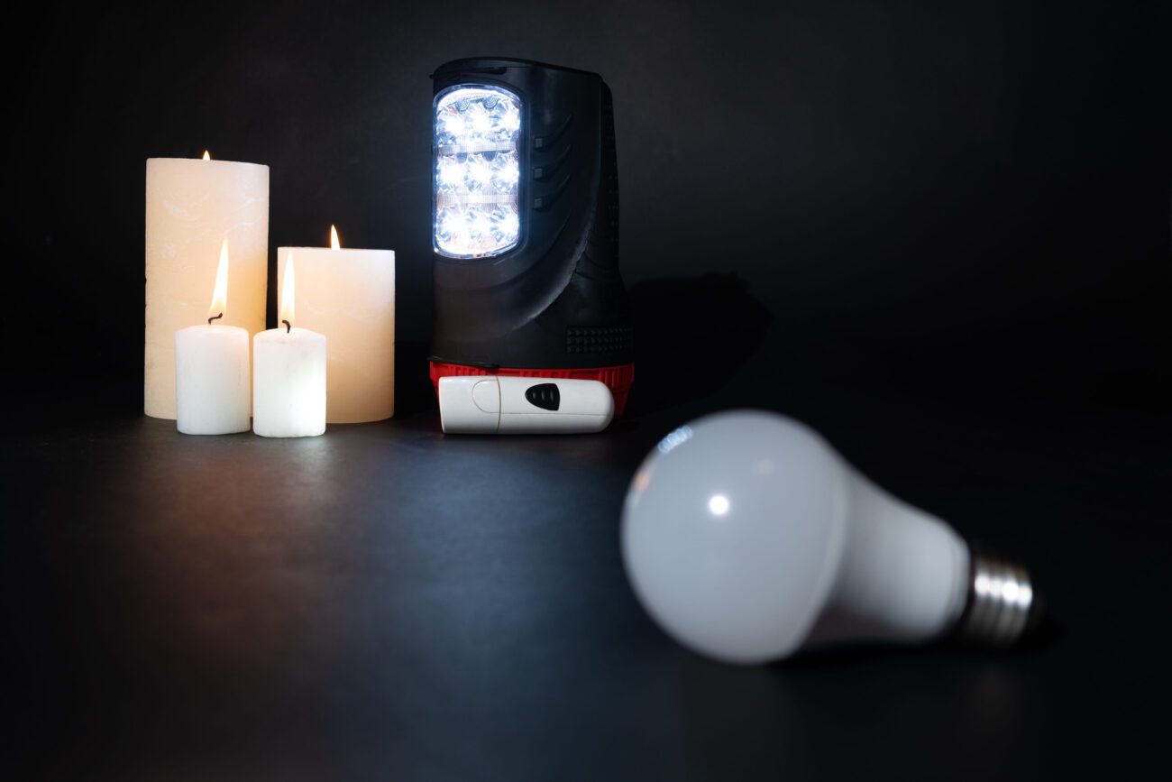 Candles and a portable LED work light on a dark surface, with a loose LED bulb in the foreground.&nbsp;Hispamer Noticias